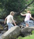 Children playing on stones in river